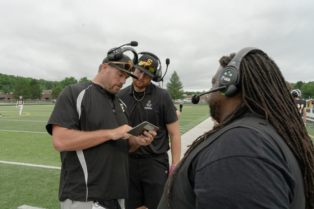 football coaches huddled on sidelines
